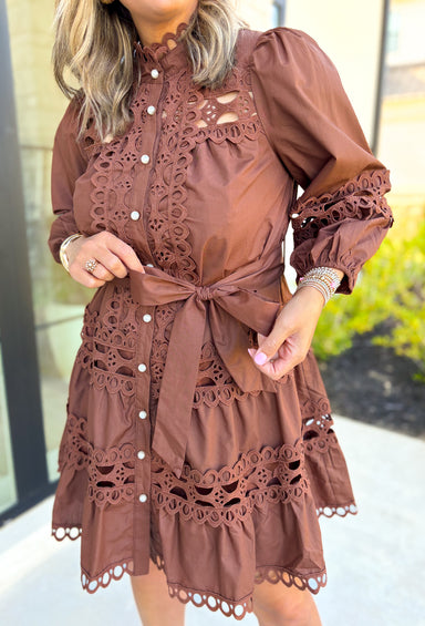 Simply Chic Dress in Brown, long sleeve pearl button down dress with eyelet lace details on the body, tiers and sleeves of the dress, tie belt detail around the waist, scallop lace detail on the hem of the dress as well as the collar 