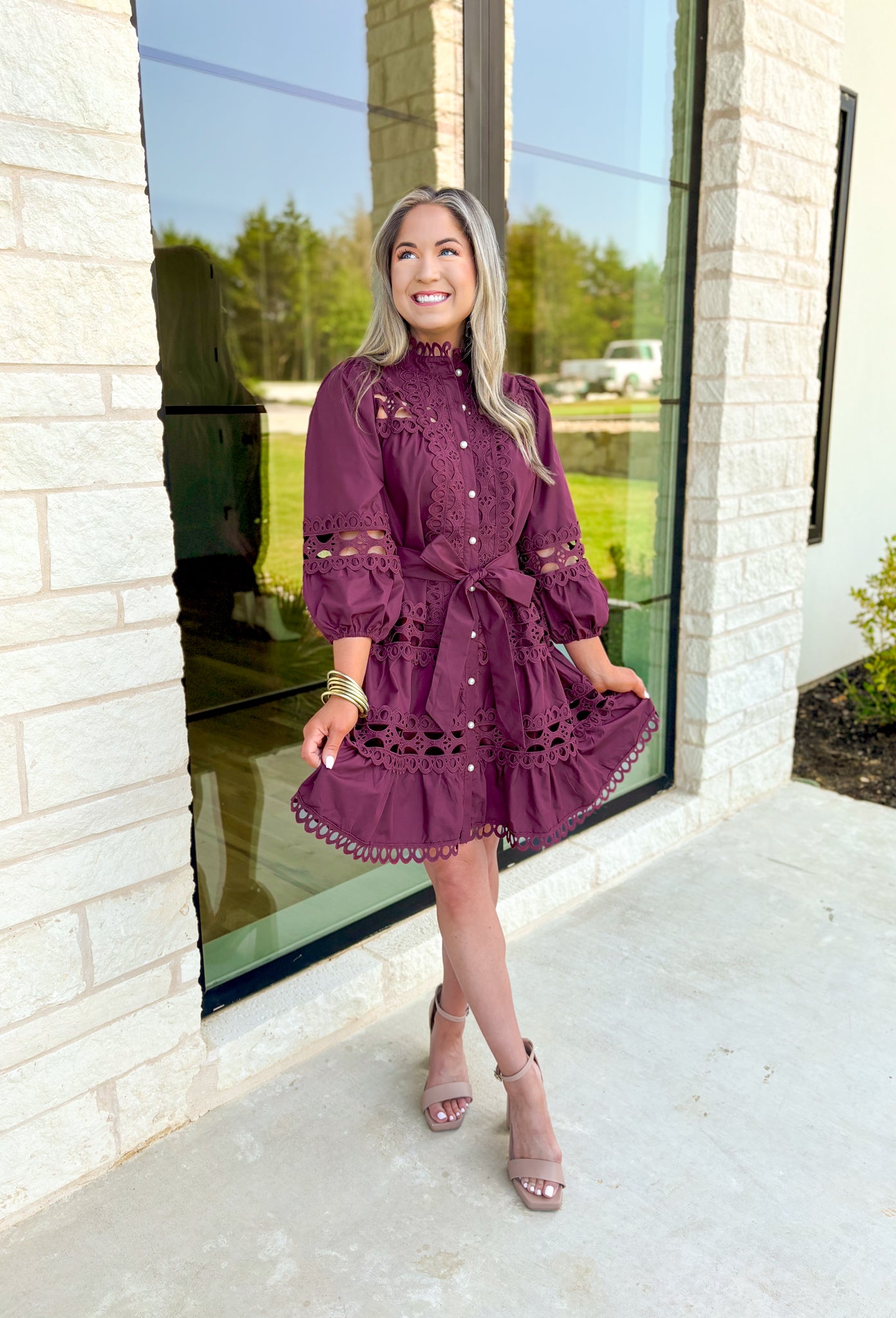 Simply Chic Dress in Merlot, long sleeve pearl button down dress with eyelet lace details on the body, tiers and sleeves of the dress, tie belt detail around the waist, scallop lace detail on the hem of the dress as well as the collar 