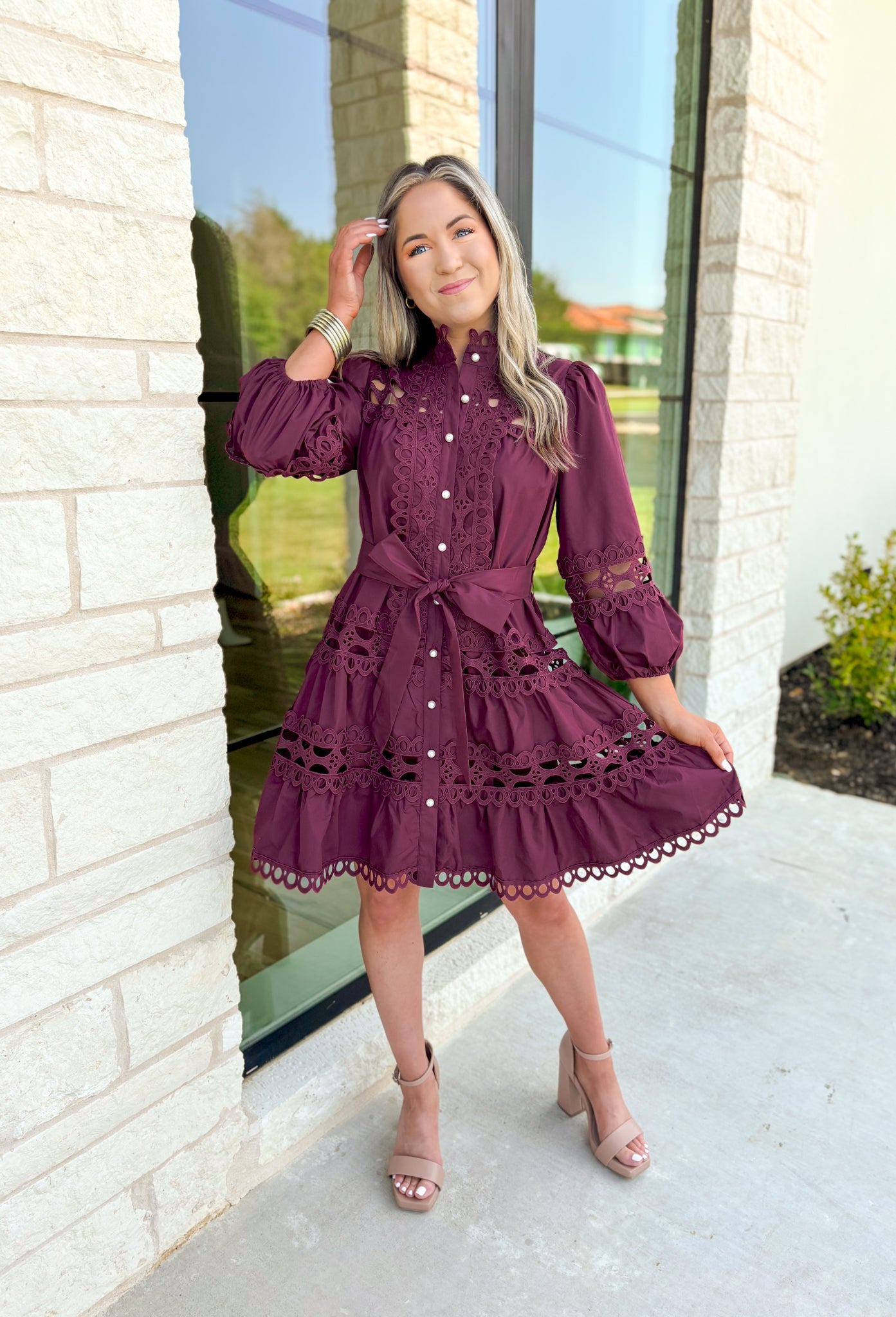 Simply Chic Dress in Merlot, long sleeve pearl button down dress with eyelet lace details on the body, tiers and sleeves of the dress, tie belt detail around the waist, scallop lace detail on the hem of the dress as well as the collar 