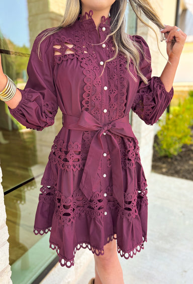 Simply Chic Dress in Merlot, long sleeve pearl button down dress with eyelet lace details on the body, tiers and sleeves of the dress, tie belt detail around the waist, scallop lace detail on the hem of the dress as well as the collar 