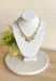 Talk About It Necklace, gold paper chain link necklace with a variation of gold charms with different details on them such as pearls, diamonds, and other designs 