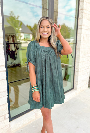 Talk It Out Dress, faded pine green short puff sleeve mini dress with a square neck line, crinkle texture, bow detail on the sleeves 