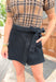 The Truth Is Denim Skort, black denim skort with braided detail on the waist and hem, tie detail on the left side of the skirt