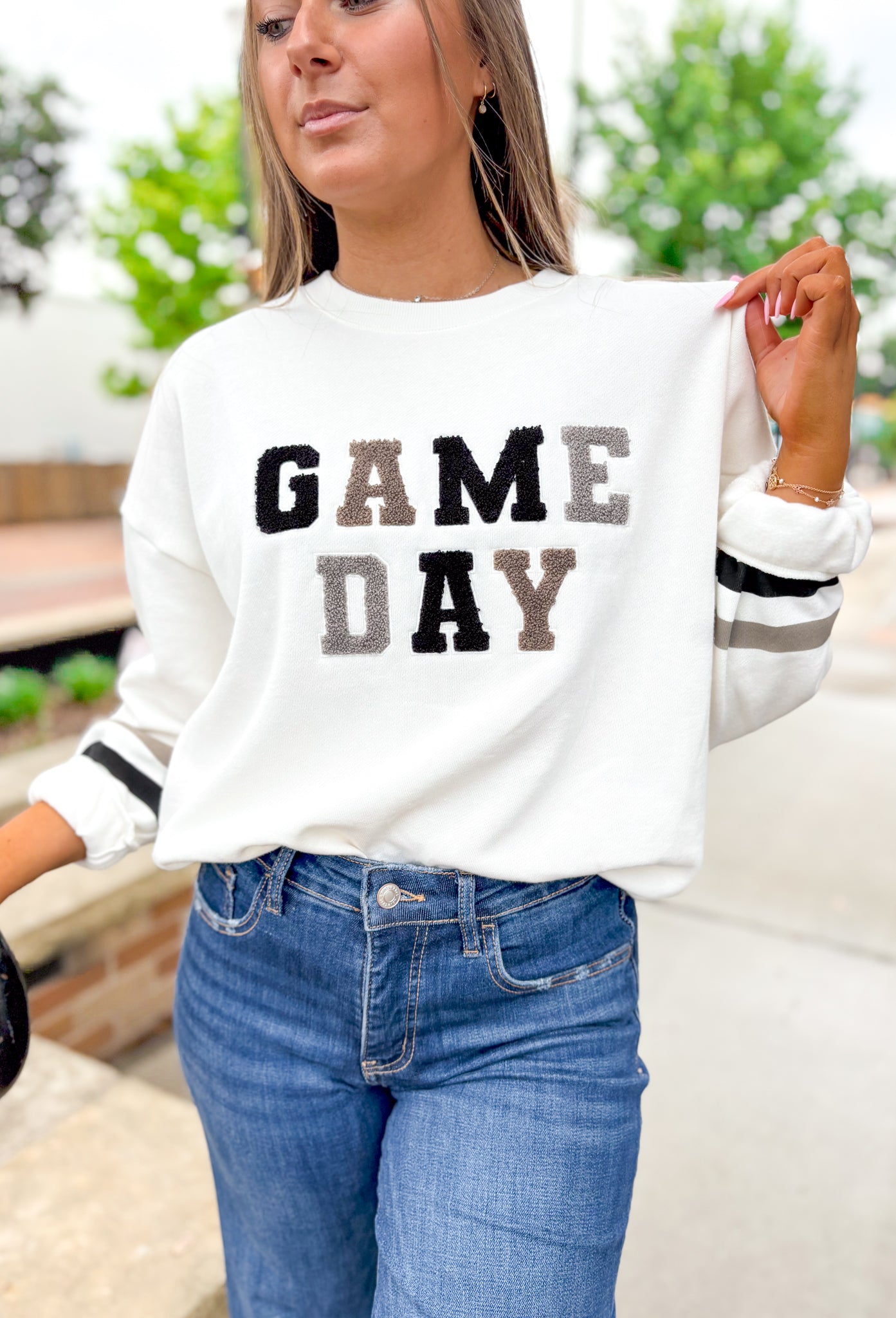 Z SUPPLY Oversized Game Day Sweatshirt in Bone, white crewneck with "game day" spelt out in black, gray, and taupe patches, sleeves have a taupe and black stripe on the wrist 