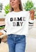 Z SUPPLY Oversized Game Day Sweatshirt in Bone, white crewneck with "game day" spelt out in black, gray, and taupe patches, sleeves have a taupe and black stripe on the wrist 