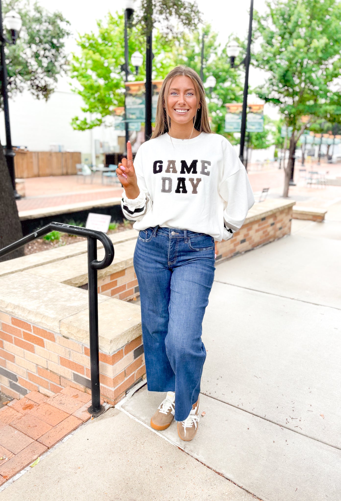 Z SUPPLY Oversized Game Day Sweatshirt in Bone, white crewneck with "game day" spelt out in black, gray, and taupe patches, sleeves have a taupe and black stripe on the wrist 