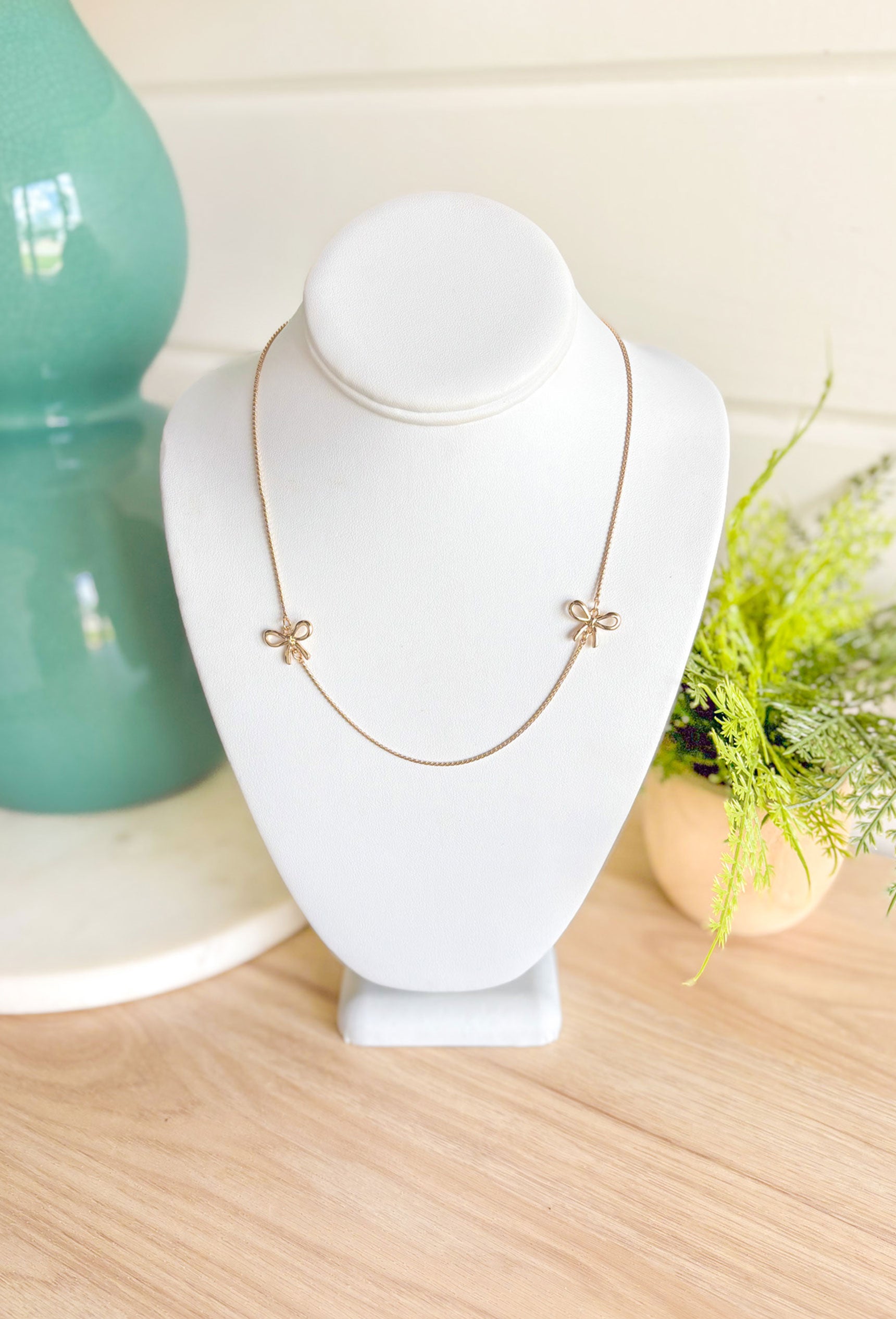 The Only Way Necklace, dainty gold chain necklace with two gold bows on either side of the middle of the chain 