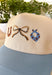 This neutral trucker hat is finished with a soft light blue bill for a fresh, easygoing look. Featuring an embroidered western-inspired design on the front, it adds just the right amount of character while staying effortlessly wearable. The adjustable back ensures a comfortable fit, making it perfect for everyday errands, outdoor plans, or topping off a casual outfit.