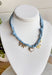 Playful and trendy, this light blue bandana necklace is full of personality. Detailed with a mix of eclectic charms—including a sparkling crystal cross, gold bow, white heart, gold pendant, and a gold cowboy boot—it’s the perfect statement piece to add fun flair to any outfit. With a 15" length and 3" extender, you can adjust it to layer with other necklaces or let it shine on its own. A must-have for adding a pop of charm to your wardrobe.