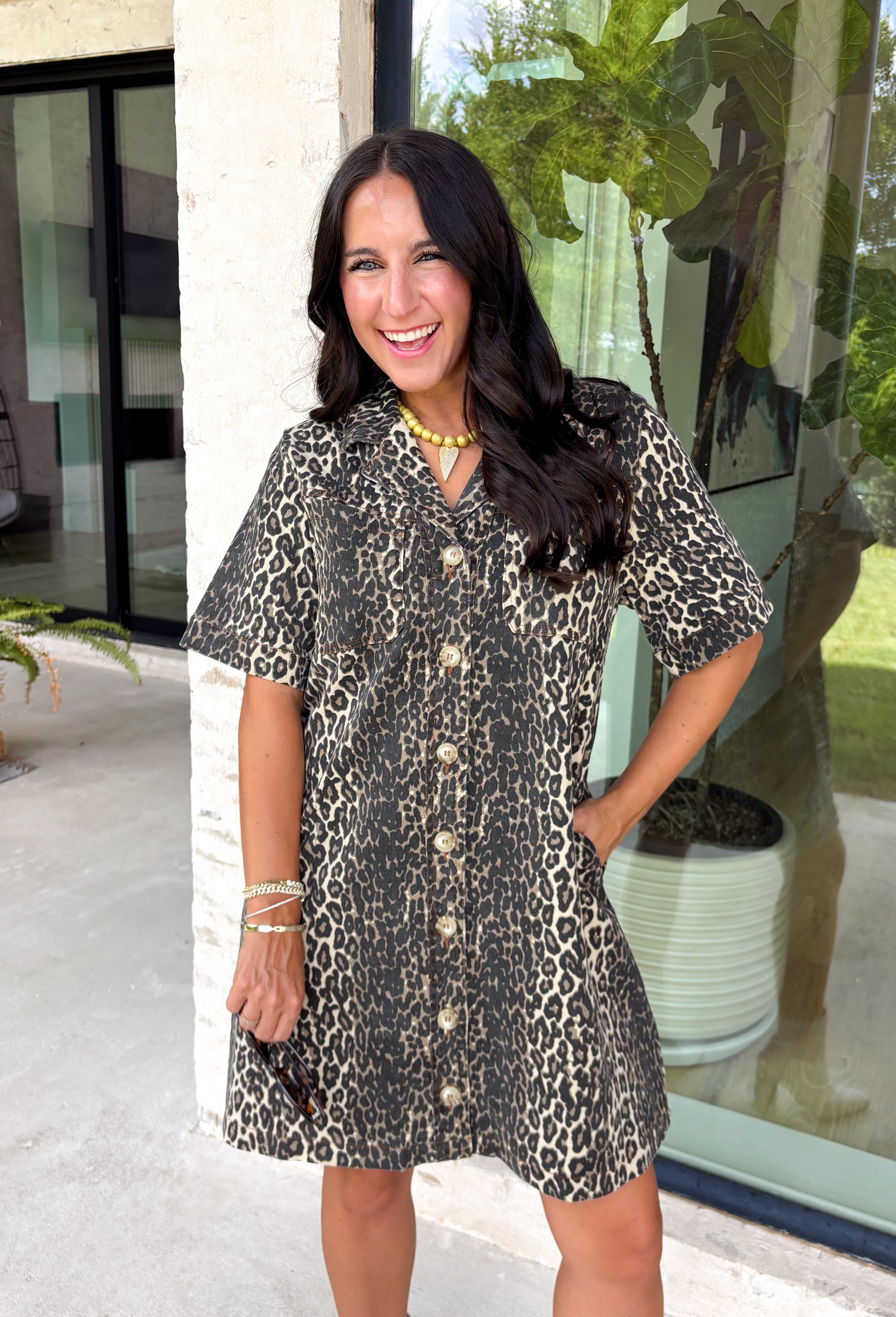 Classic denim meets a timeless animal print in this effortlessly stylish dress. This neutral leopard print denim dress is the perfect balance of bold and versatile. The button-front design and short sleeves give it an easy, everyday feel, while the front patch pockets and side pockets add both charm and function. Crafted from a soft cotton blend with just the right amount of stretch, this dress is made for everything from casual weekends to lunch dates and fall adventures.