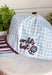 Bring a little fun to your everyday look with this charming trucker hat that's full of playful personality. Featuring a light blue and white gingham front paired with a light blue and brown striped bill, this unique hat is finished with white embroidered detailing along the bill for an extra touch of texture. The front is embroidered in chocolate brown with "Dilly Dally-er," while the side proudly reads "World's Best" with a ribbon. 