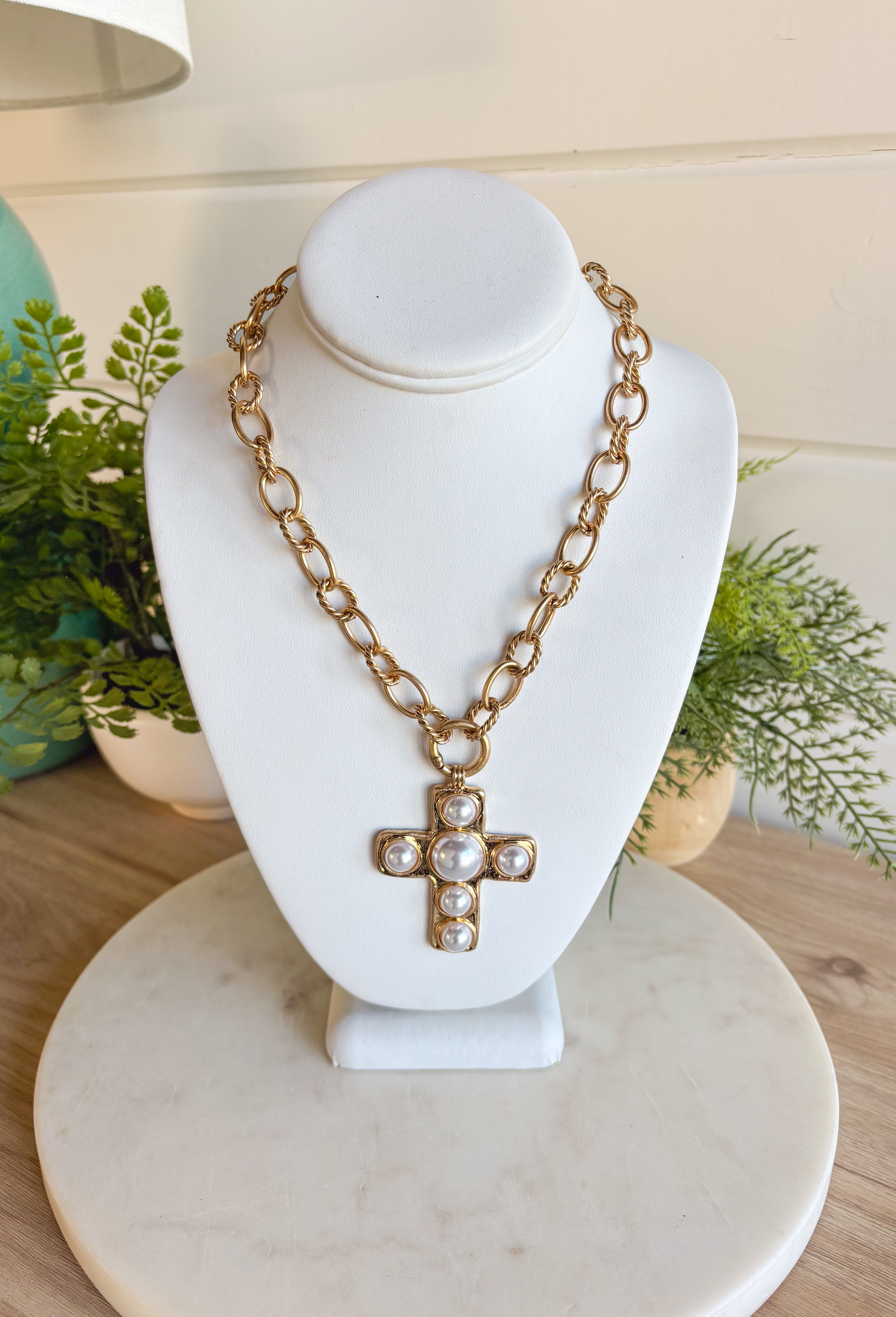 This chunky gold chain necklace makes a bold yet timeless statement. Featuring a gold cross adorned with pearls, it blends modern edge with classic elegance. The toggle clasp closure adds a stylish touch while keeping it easy to wear. Perfect for elevating casual looks or adding a refined accent to dressier outfits.