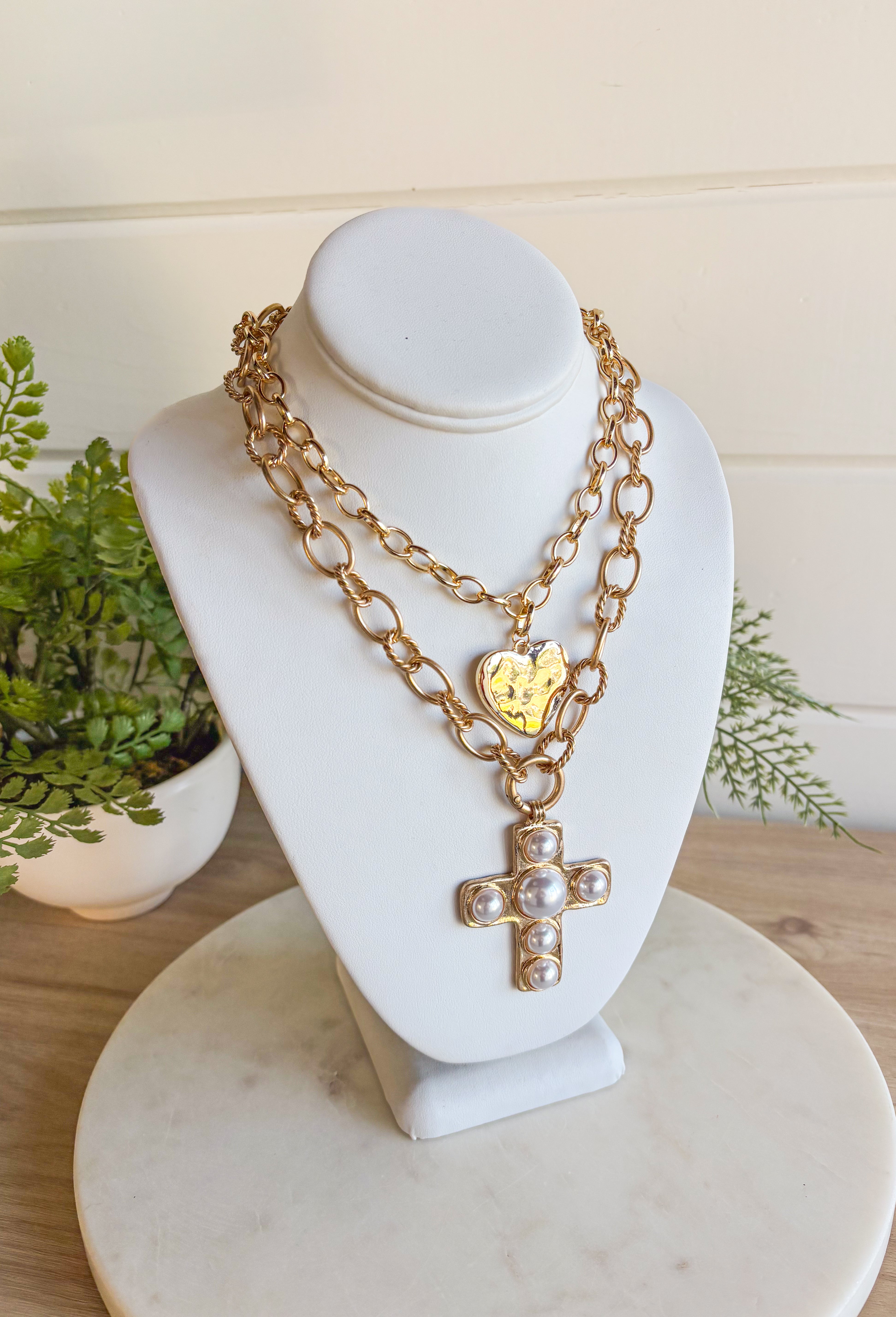 This chunky gold chain necklace makes a bold yet timeless statement. Featuring a gold cross adorned with pearls, it blends modern edge with classic elegance. The toggle clasp closure adds a stylish touch while keeping it easy to wear. Perfect for elevating casual looks or adding a refined accent to dressier outfits.