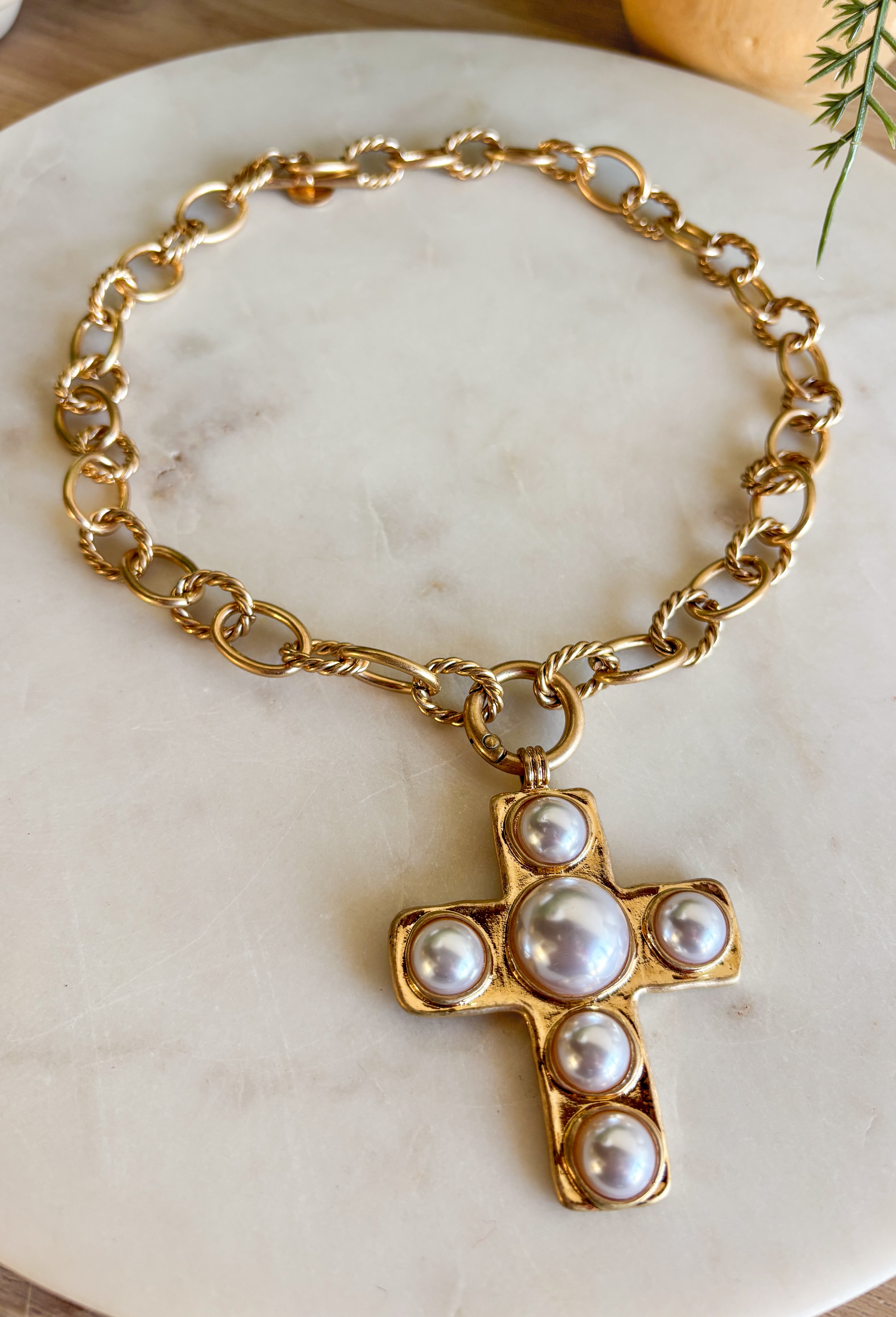 This chunky gold chain necklace makes a bold yet timeless statement. Featuring a gold cross adorned with pearls, it blends modern edge with classic elegance. The toggle clasp closure adds a stylish touch while keeping it easy to wear. Perfect for elevating casual looks or adding a refined accent to dressier outfits.