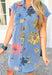 Feels Like Summer Dress, medium wash short sleeve button down denim dress with two pockets on the chest and pockets, pinkish red, yellow, and blue enlarged floral design covering the dress with charcoal outlines 