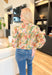 Last Chance Floral Blouse, long sleeve blouse with palm leaves and flowers, smocking on the wrist, quarter button down detail, in the colors amazon green, yellow, cream, orange, aqua, fuchsia, gold detail throughout the blouse