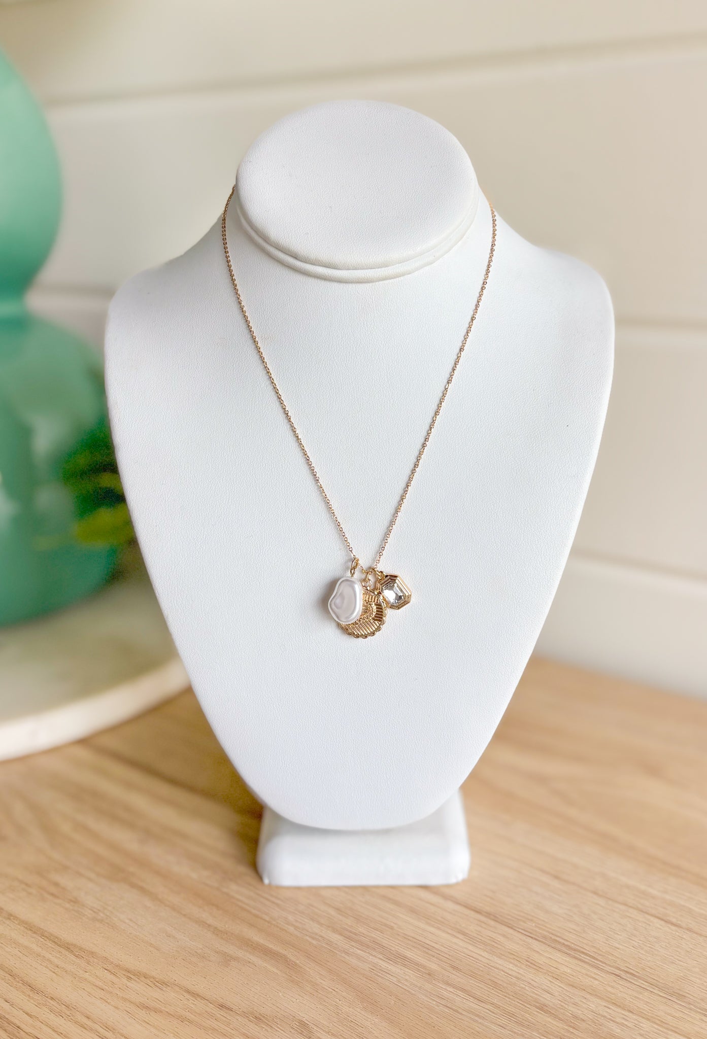 On Your Own Necklace, dainty gold chain with pearl, gold snake pendant, and gold brimmed rhinestone charms in the center 