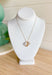 On Your Own Necklace, dainty gold chain with pearl, gold snake pendant, and gold brimmed rhinestone charms in the center 