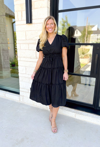 Worth The Risk Midi Dress, black puff sleeve midi dress with tiering, ruffling on the hem of each tier, v-neck line, cinching at the waist with a bow detail 